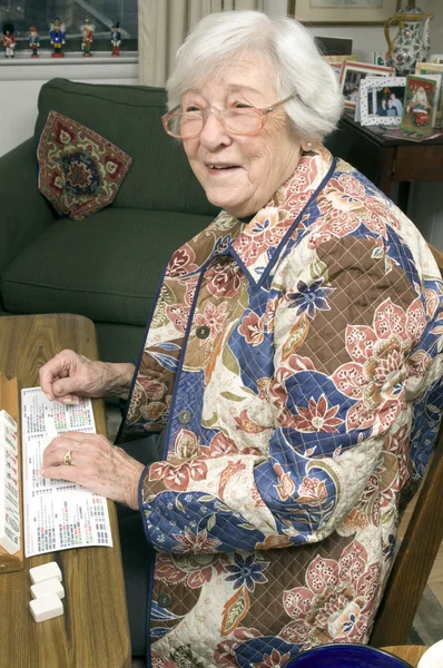 Senior woman at the game table — Stock Photo, Image