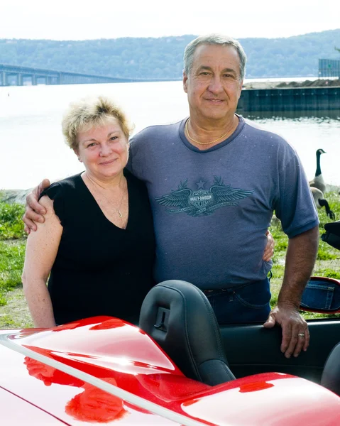 Чоловік і жінка червоний спортивний автомобіль — стокове фото
