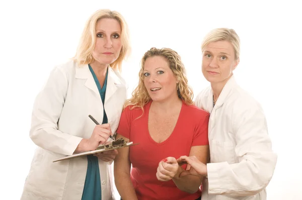 Two doctors nurses in medical scrubs clothes with patient — Stock Photo, Image