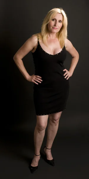 Glamorous middle age woman posing in black dress — Stock Photo, Image