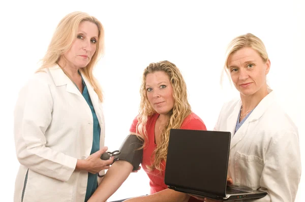 Two doctors nurses in medical scrubs clothes with patient — Stock Photo, Image