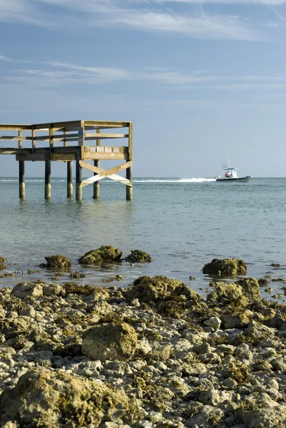 Pier skalnatého pobřeží s lodí — Stock fotografie