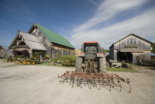 Traktor traktor miring di depan taman pusat di pedesaan Vermont — Stok Foto