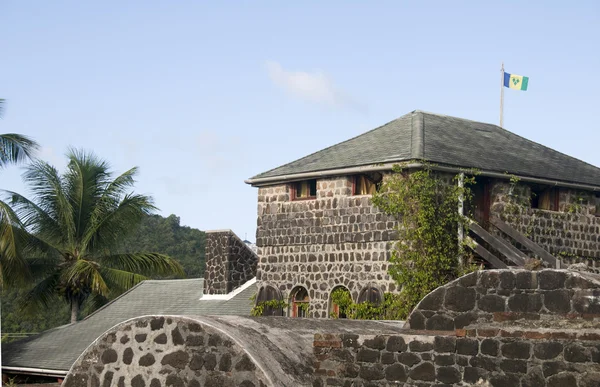 Stary fort z banderą st. vincent w bequia st. vincent i Grenadyny z rodzimą flagą — Zdjęcie stockowe