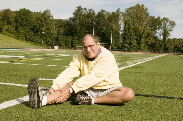 Uomo anziano di mezza età che esercita sul campo sportivo — Foto Stock