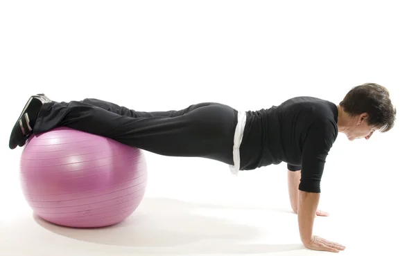 Senior vrouw fitness oefening push-ups met kern opleiding bal — Stockfoto