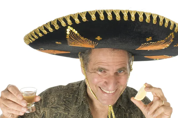 Turista de mediana edad vestido con sombrero mexicano bebiendo tequila shot —  Fotos de Stock