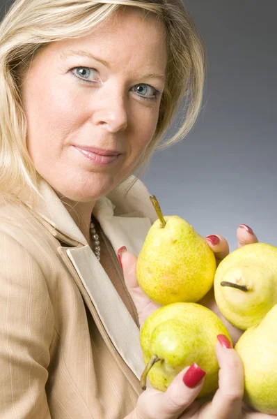 Atrakcyjny blond kobieta z owoców gruszki do zdrowego stylu życia — Zdjęcie stockowe
