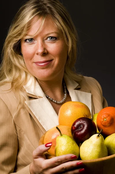 Pretty older woman in suit fruit bowl — Stock Photo, Image