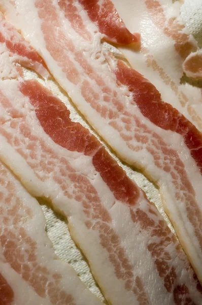 Raw bacon strips on paper towel for microwave — Stock Photo, Image