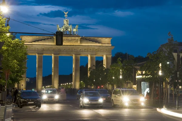 Porta di Brandeburgo illuminata di notte con traffico pedonale su Unter den Linden Berlino Germania Europa — Foto Stock