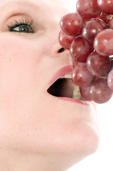 Mulher comendo uvas vermelhas frescas — Fotografia de Stock
