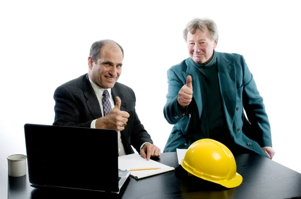 Two business partners at desk shaking hands — Stock Photo, Image