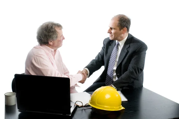 Två affärspartners vid skrivbord som skakar hand — Stockfoto