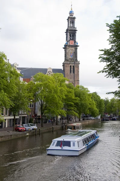 Canal scene with tourist boat westekerk amsterdam — стоковое фото