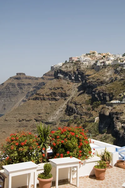 Bord med blommor och utsikt över stan på caldera vulkaniska klippor — Stockfoto