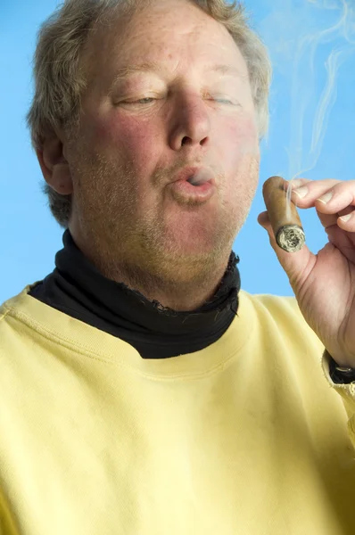 Komea keski-ikäinen mies polttaa kallista sikaria — kuvapankkivalokuva