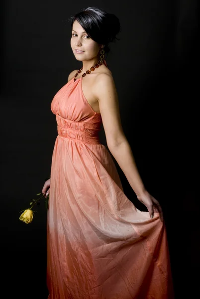 Rose'la güzel elbise gülümseyen düzgün genç ve güzel kadın — Stok fotoğraf