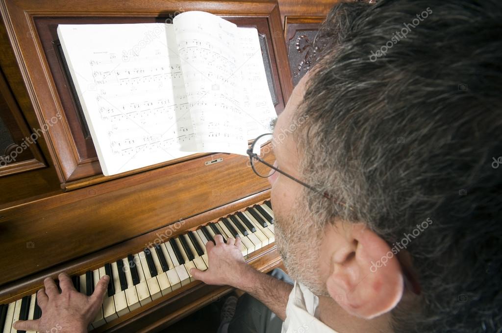 senior middle age man playing piano