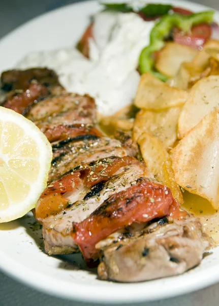 Espetos de Souvlaki de porco, tzatziki, salada, batatas fritas, fotografadas, restauarante de taverna, Cíclades, ilha grega, Grécia — Fotografia de Stock