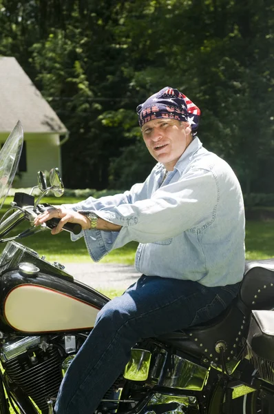 Homem de meia idade na motocicleta com bandeira americana bandana — Fotografia de Stock