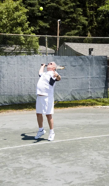 Middle age tennis player serving the ball on court — Stock Photo, Image