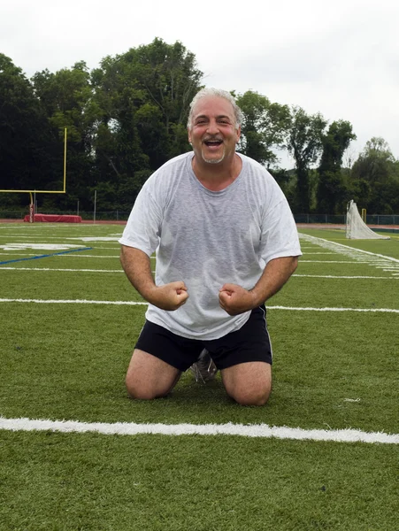 Homem de meia idade alongamento e exercício no campo de esportes — Fotografia de Stock