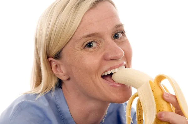 Enfermera persona médica comer plátano —  Fotos de Stock