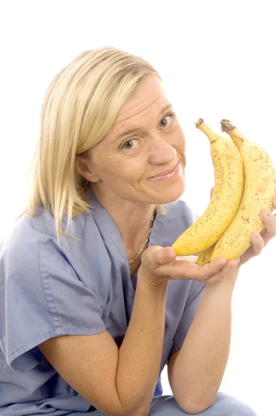 Χαμογελώντας ευτυχούς νοσοκόμας γιατρός με υγιή φρέσκο δέσμη ώριμες μπανάνες — Φωτογραφία Αρχείου