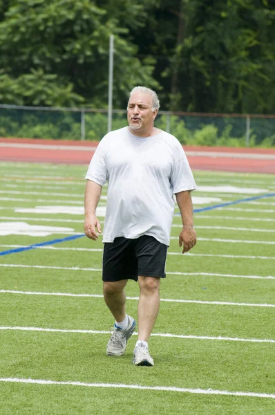 Middle age man exercising on sports field — Stock Photo, Image