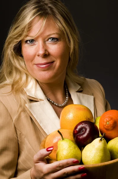 Vrij oudere vrouw in pak fruitschaal — Stockfoto