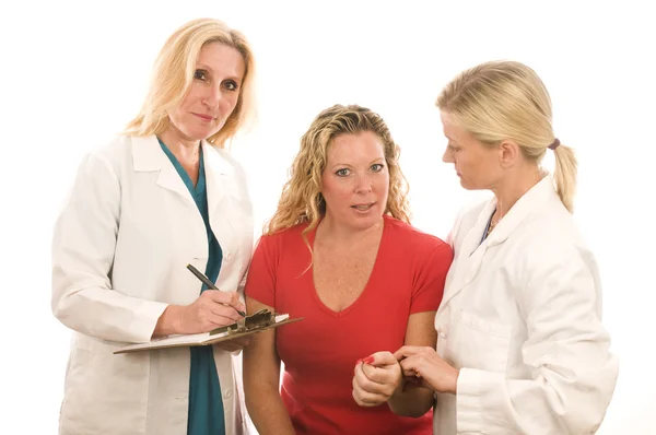 Zwei Ärzte Krankenschwestern in medizinischem Peeling Kleidung mit Patient — Stockfoto