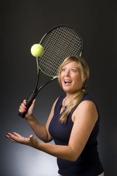 Mulher jogador de tênis feliz servindo bola — Fotografia de Stock