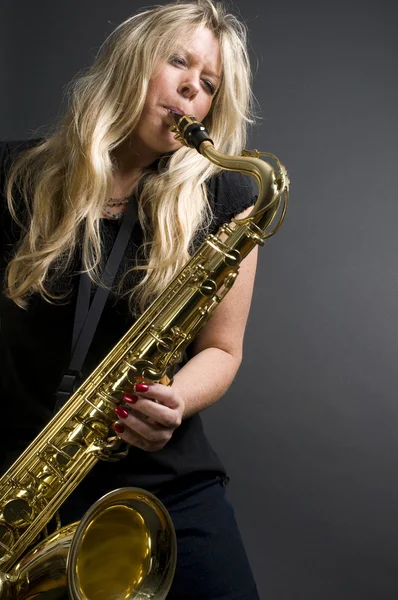 Sexy blonde vrouwelijke saxofoon speler musicus — Stockfoto