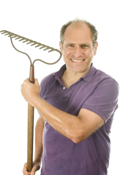 Пожилой человек среднего возраста с садовыми носовыми граблями — стоковое фото