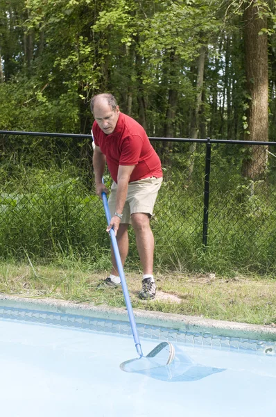 homeowner cleaning swimming pool