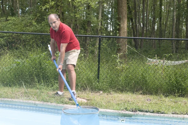 Pemilik rumah membersihkan kolam renang — Stok Foto