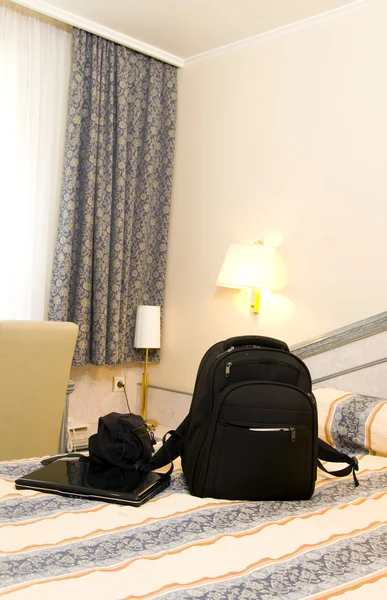 Hotel room with backpack and laptop on bed — Stock Photo, Image