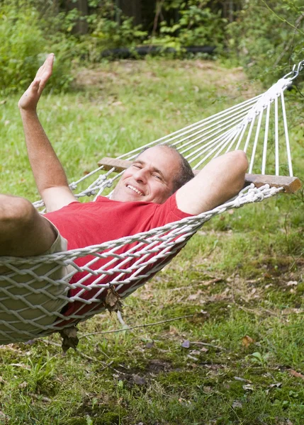 Mosolygó középkorú ember pihentető függőágy — Stock Fotó