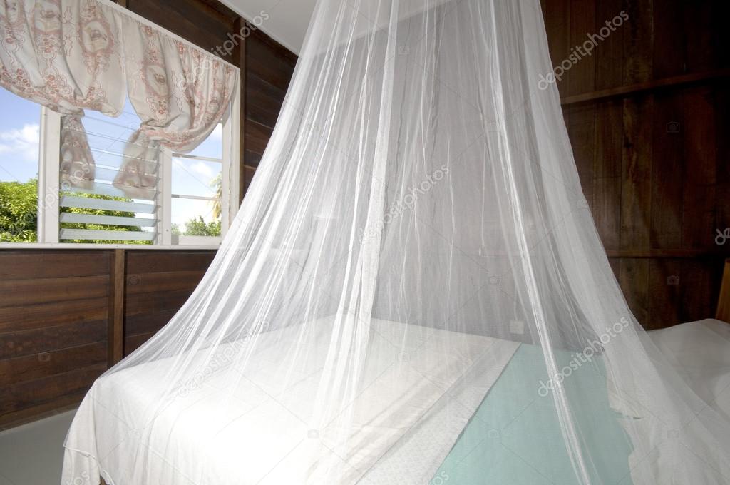 bedroom with mosquito net in budget guest house bequia