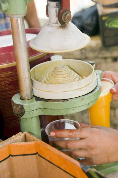 Trabalhador espremendo suco de laranja fresco velho moda suco imprensa ma — Fotografia de Stock