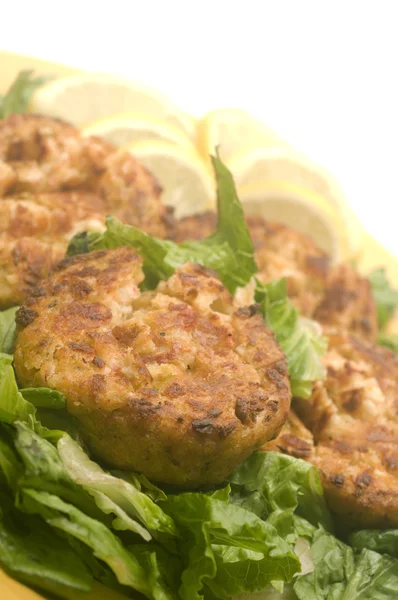 Lobster cakes bed of lettuce with lemon slice wedges — Stock Photo, Image