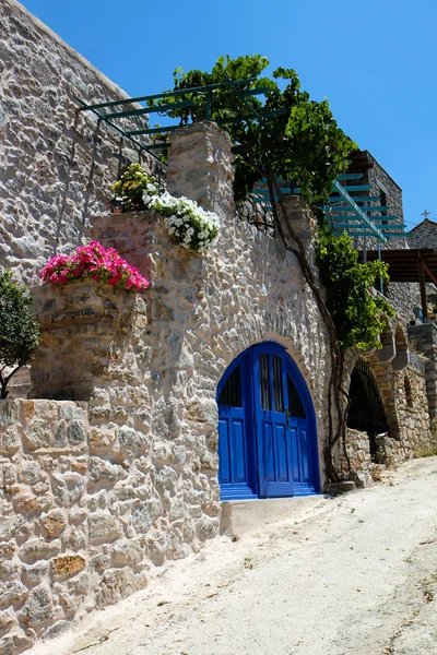 Casa grega com porta azul e flores — Fotografia de Stock