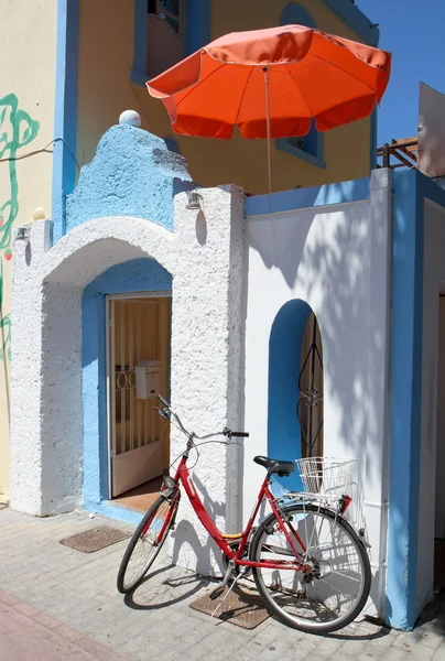 Maison grecque avec parapluie et vélo — Photo