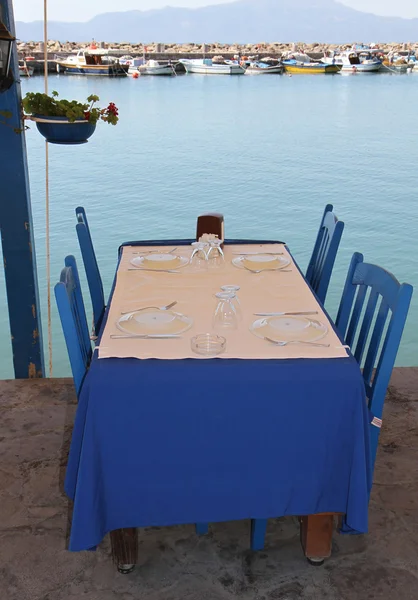 Pescado restaurante almuerzo ajuste con mantel azul y tapa de papel por el mar Egeo — Foto de Stock