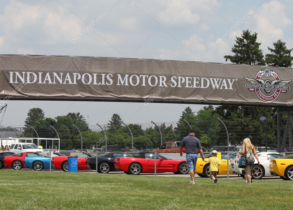 Family of three walking towards Colorful Corvettes in line at the Indianapolis Motor Speedway Parking Lot at Indy 500 Festival Community Day.