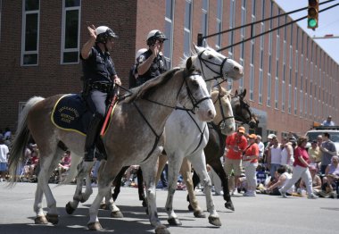 Indianapolis atlı polis yarış hayranları 500 festival geçit töreni sırasında selamlıyor.