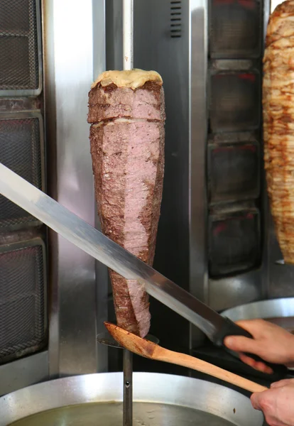 Cook Slicing Turkish Lamb Doner Kebab with a Sharp Sword like Knife — Stock Photo, Image