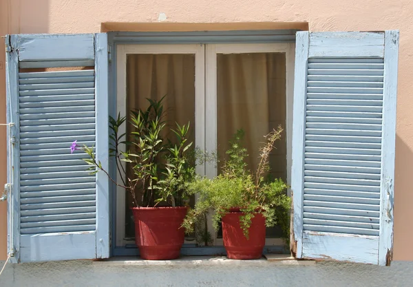 Linda caixa de madeira azul grego com persianas e cortinas na casa velha — Fotografia de Stock