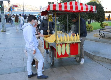 ISTANBUL,TURKEY-OCTOBER 30: Unidentified Customers buying corn near Sirkeci Train Station. October 30,2021 in Istanbul, Turkey